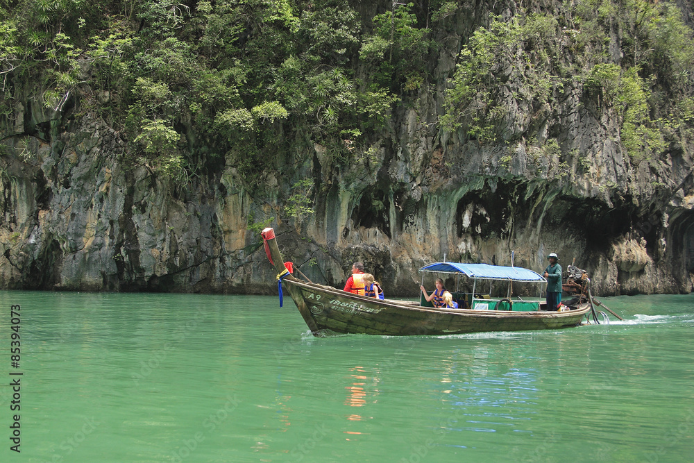 Fototapeta premium Langtailboat by Karst rock formations in the Bay of Phang Nga, Thailand, Southeast Asia