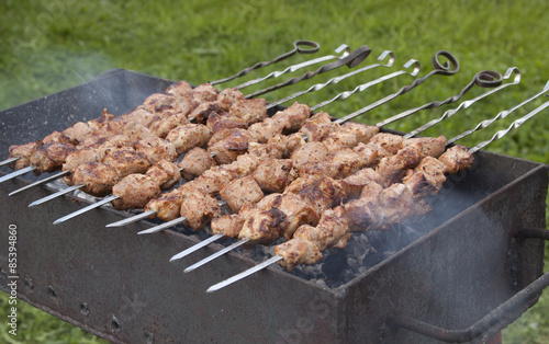 Shish kebab on skewers in the process of cooking over the coals photo