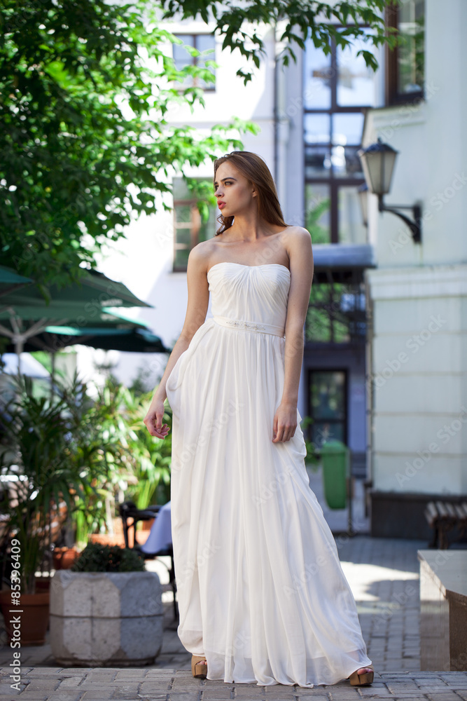 Full length portrait of beautiful model woman in white dress