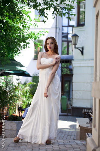 Full length portrait of beautiful model woman in white dress