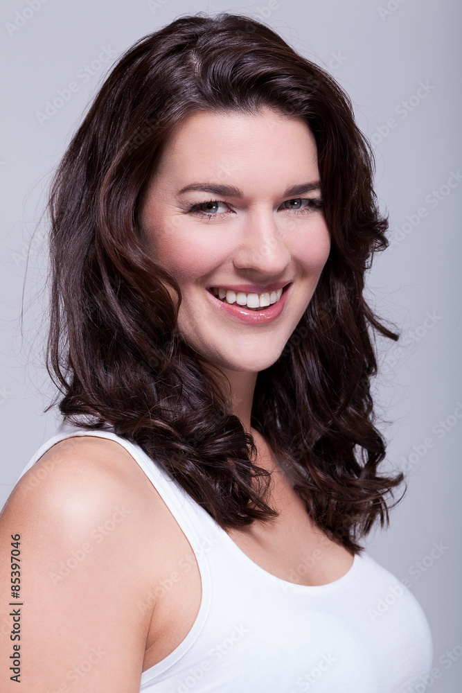 Junge attraktive Frau mit dunklen Haaren im Portrait lachend Junge attraktive Frau mit dunklen Haaren im Portrait lachend