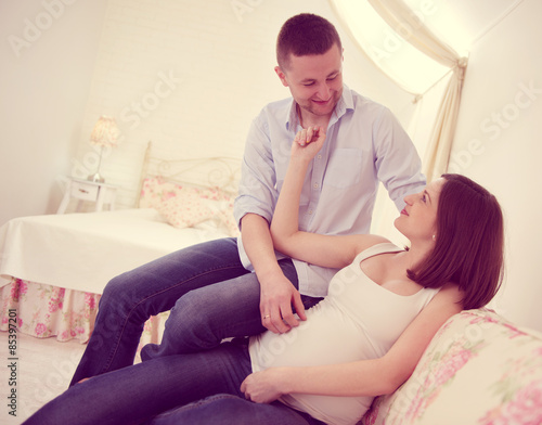 Happy pregnant couple on sofa