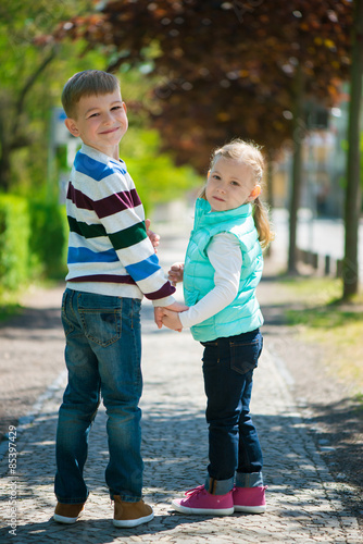 Two happy children walking in park
