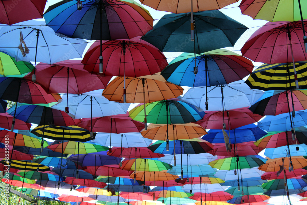 Under a rainbow of umbrellas.
Soaring in the sky multi-colored umbrellas.