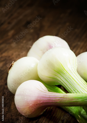 Fresh spring white onions with green stems, selective focus
