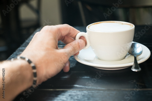 male hand holding a cup