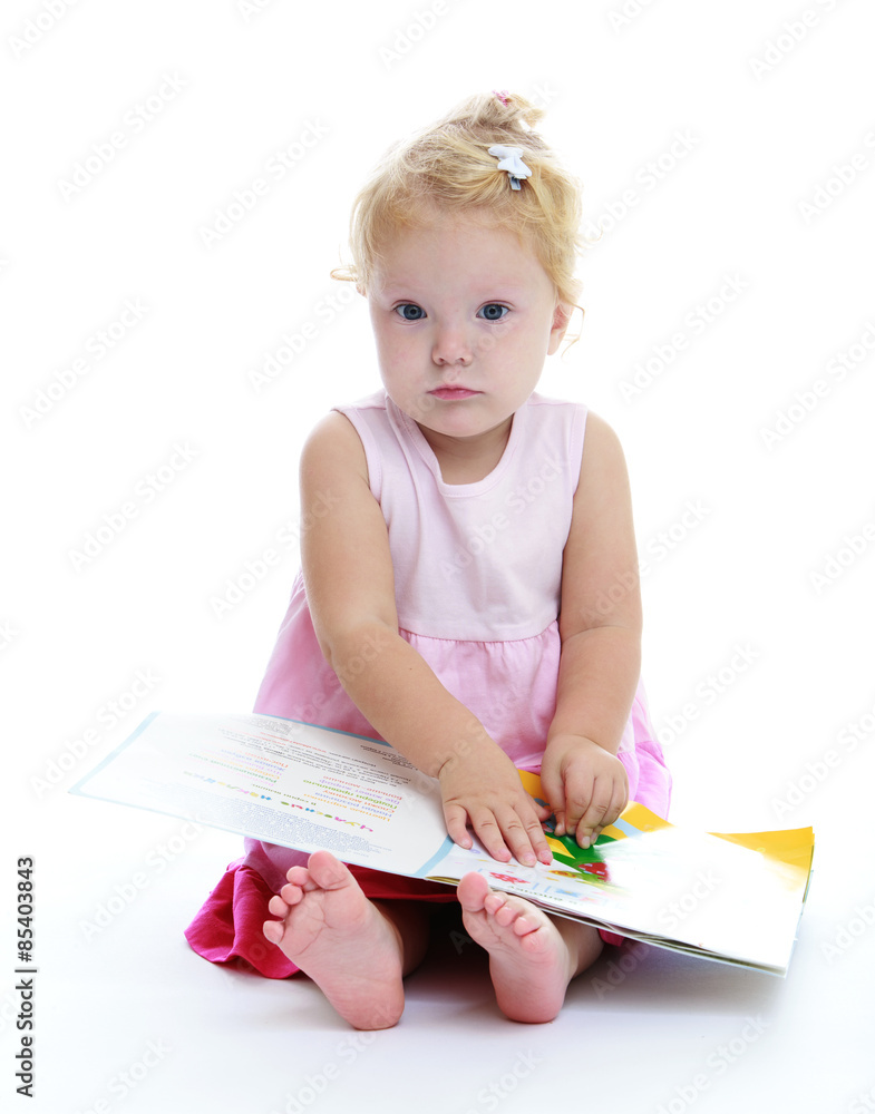 Very cute little girl reading a book sitting on the floor Very cute little girl reading a book sitting on the floor