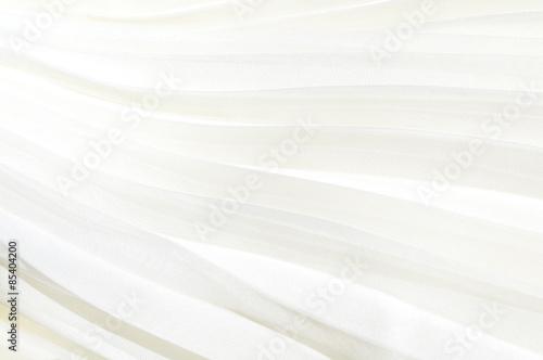 Detail of white pleated skirt. White cloth background pleated