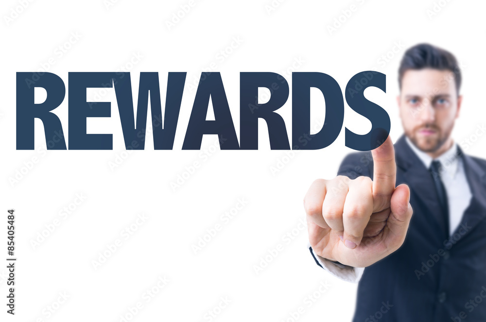 Business man pointing the text: Rewards Business man pointing the text: Rewards