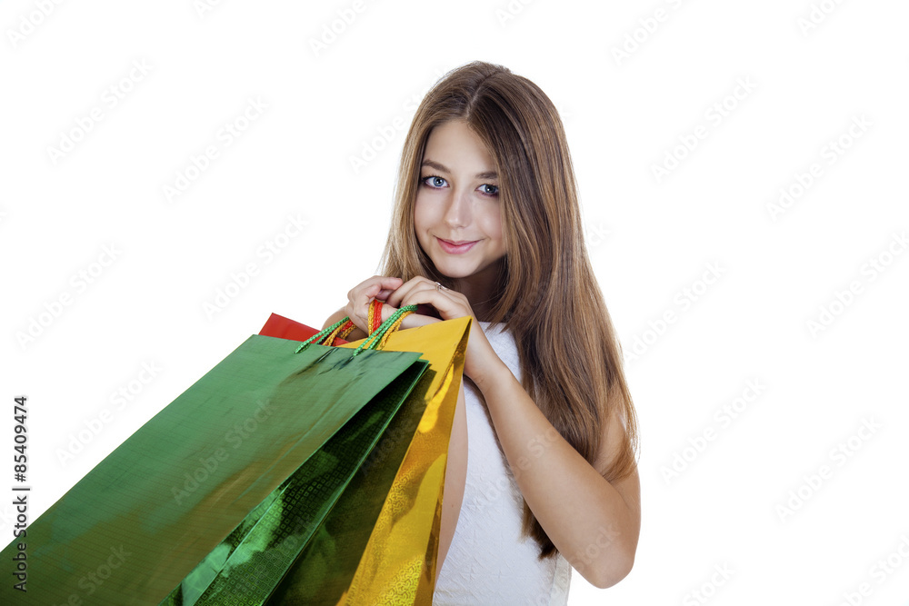Smiling young blonde girl with colorful shopping bags in white d