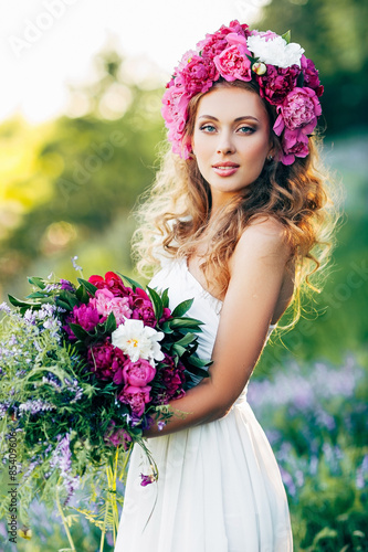 Girl with flowers in the hair in a wedding dress.