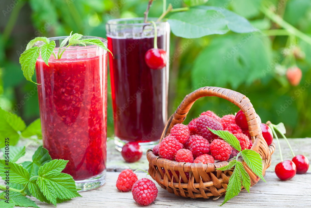 Raspberry and sour cherry juice on rustic table Raspberry and sour cherry juice on rustic table