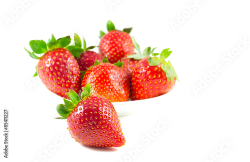 Several strawberries on a saucer focus on the front