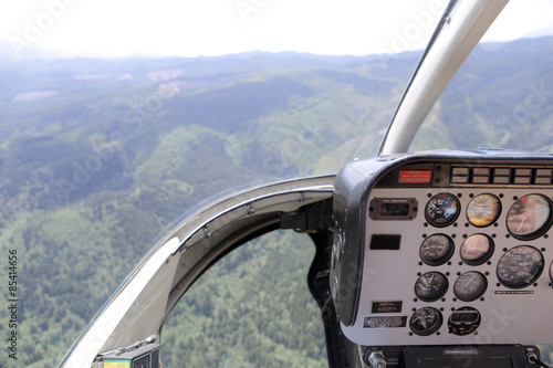 Helicopter cockpit view of the hills and forest.
