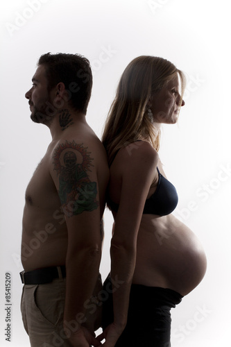 Hombre y mujer embarazada espalda contra espalda