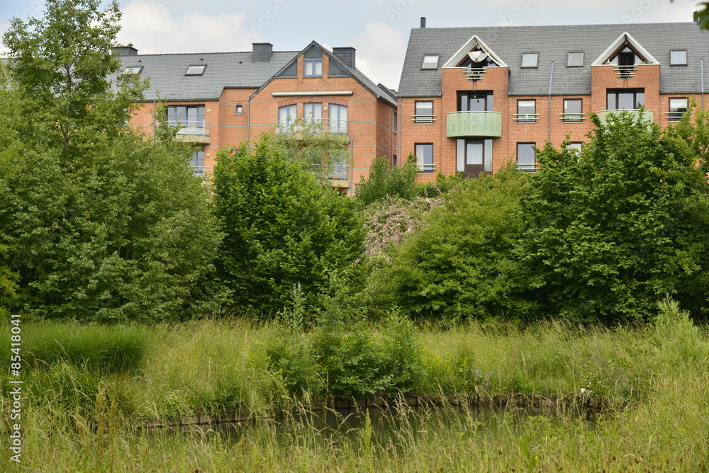 Lotissement moderne émergeant de la végétation à Louvain-la-Neuve