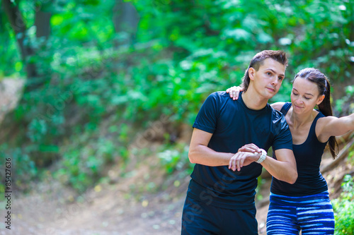Young active couple looking at smart watch heart rate monitor