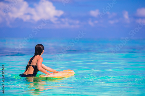 Beautiful fitness surfer woman surfing during summer vacation