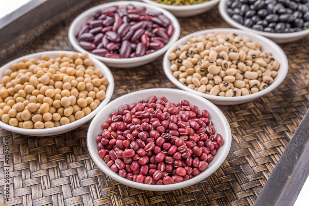 Beans variety in white bowl on in wicker tray Beans variety in white bowl on in wicker tray