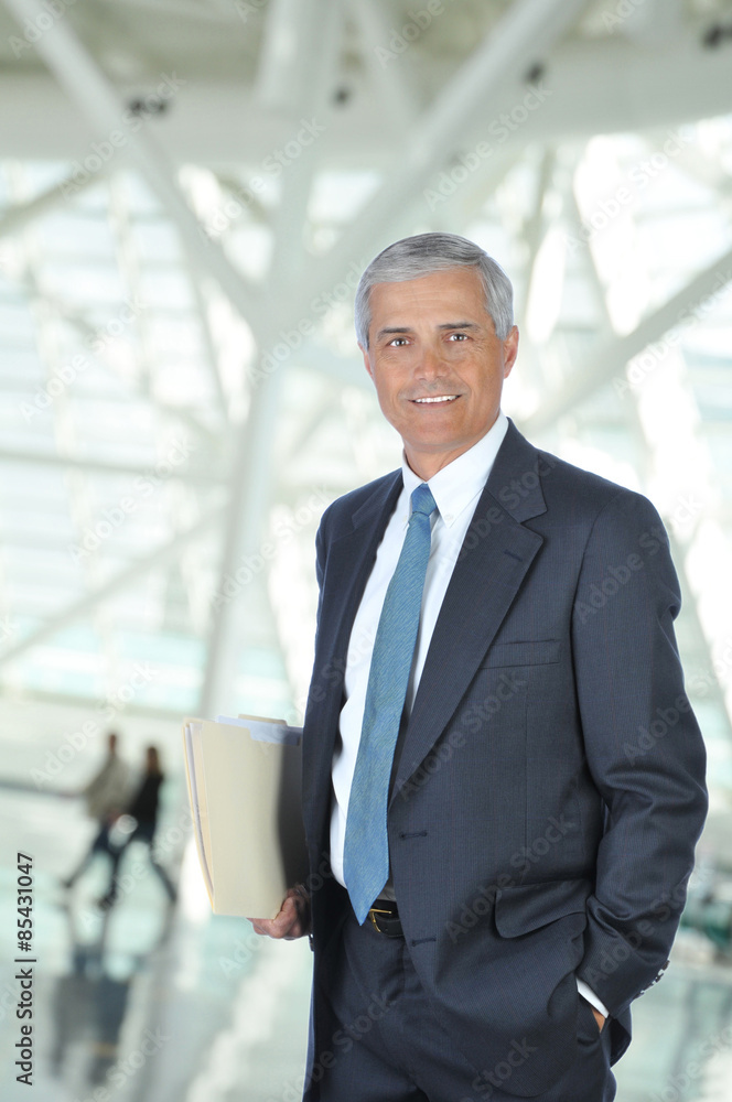Middle aged Businessman in Lobby with Folder Middle aged Businessman in Lobby with Folder