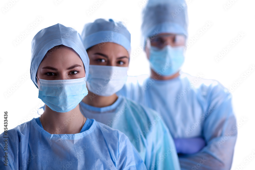 Surgeons team, wearing protective uniforms,caps and masks 