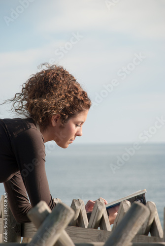 lady reading a book near the sea