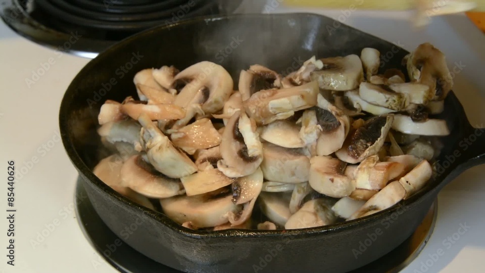 Adding sliced mushrooms to a frying pan
Adding sliced mushrooms to a frying pan