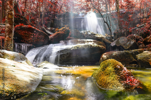 Waterfall with sunbeam in rainforest.