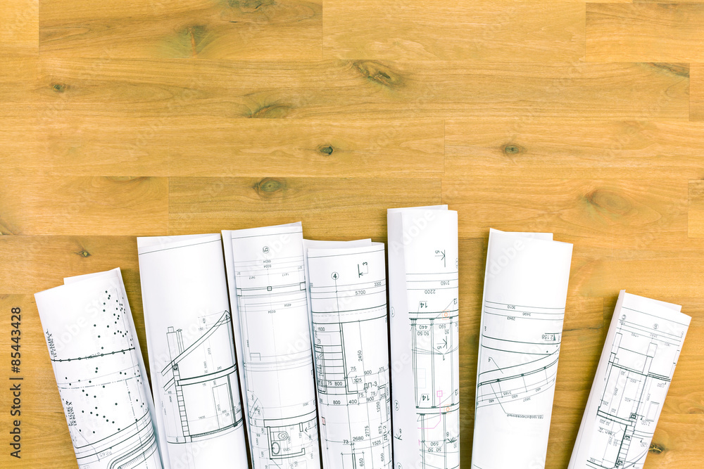 Fototapeta premium rolls of blueprints on wooden desk