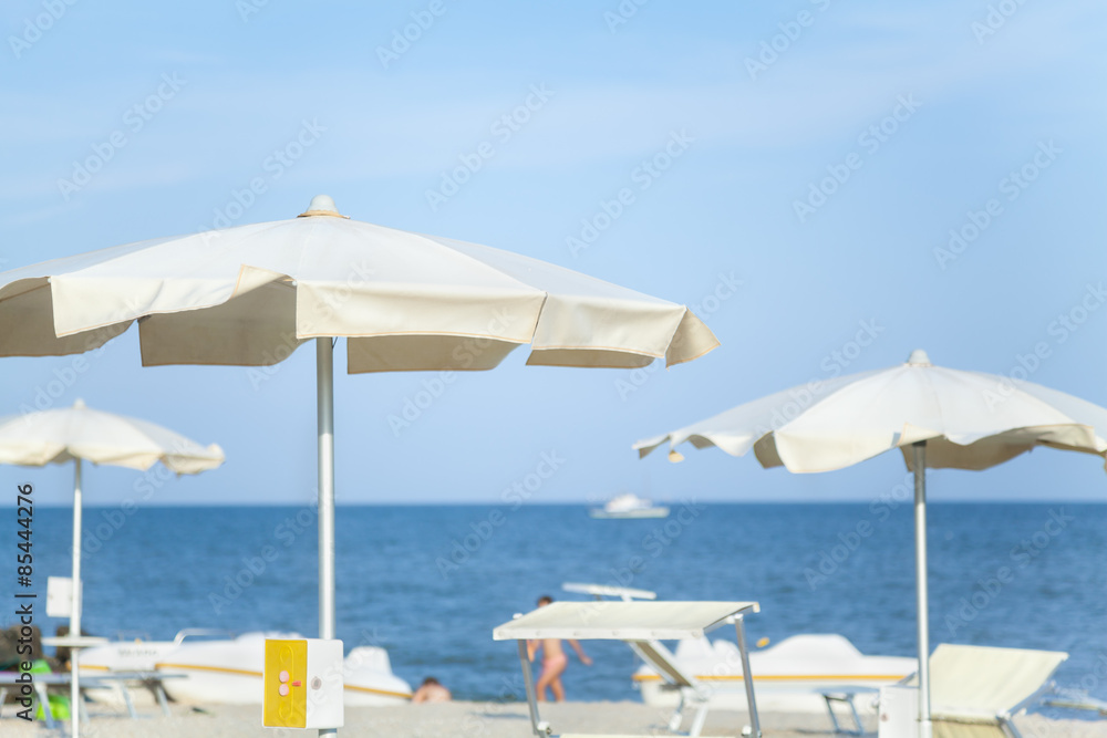 Sun umbrellas on fashionable sea beach