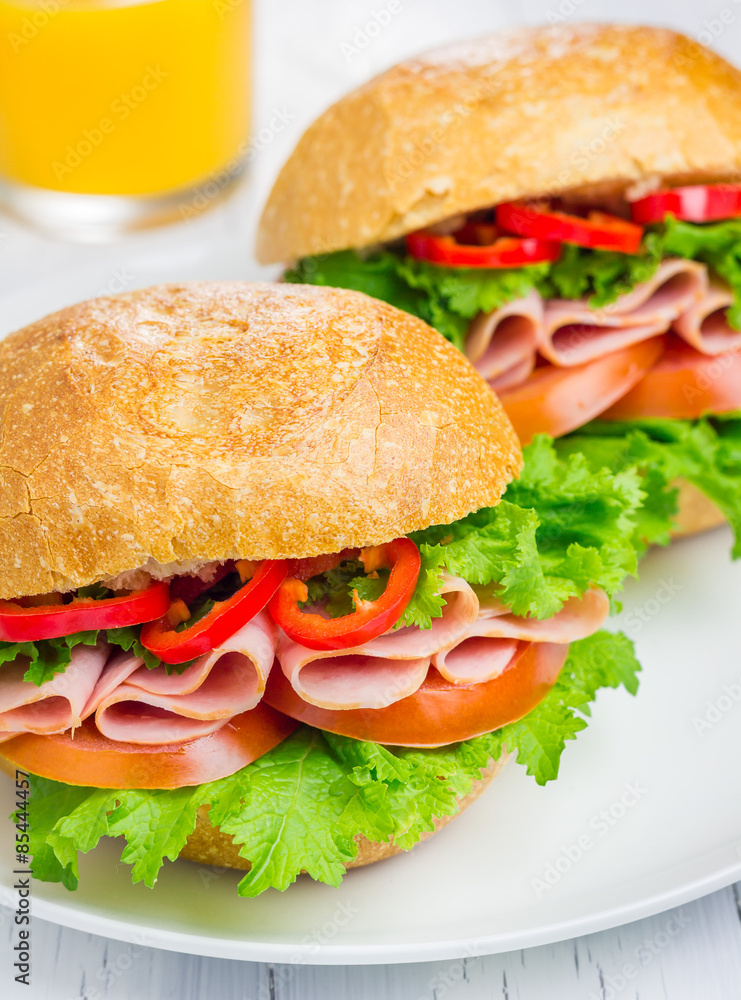 Healthy ham sandwiches on the plate with orange juice Healthy ham sandwiches on the plate with orange juice