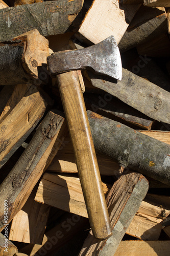 Axe on top of pile of chopped fire wood