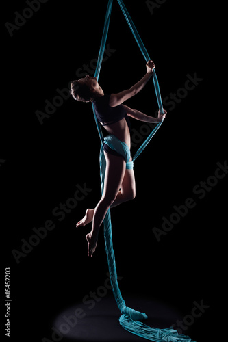 Young woman gymnast with blue gymnastic aerial silks