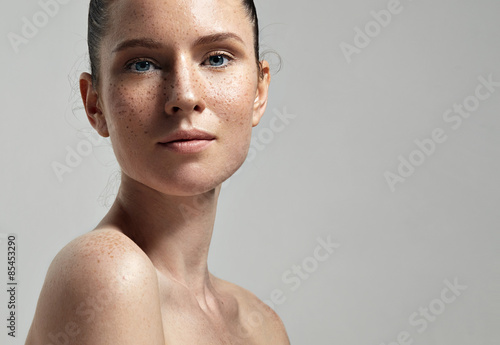 freckles woman's face portrait with healthy skin..