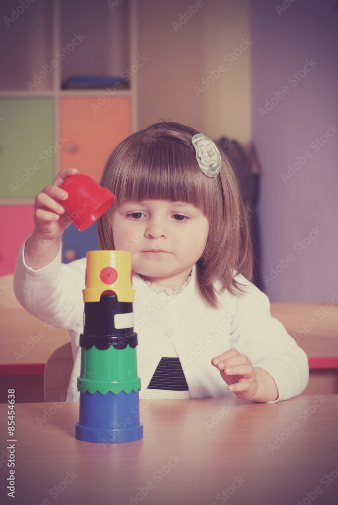 Two-year girl playing and learning in preschool Two-year girl playing and learning in preschool