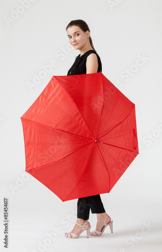 Smiling young woman holding a red umbrella © zest_marina