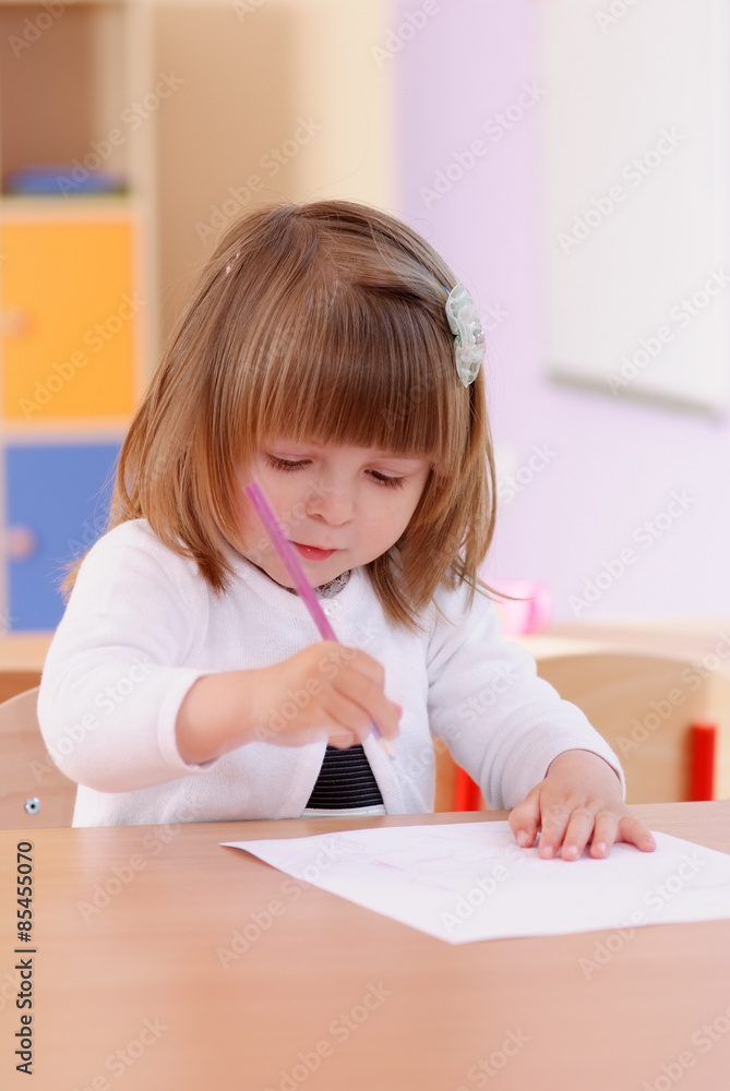 Two-year girl playing and learning in preschool Two-year girl playing and learning in preschool