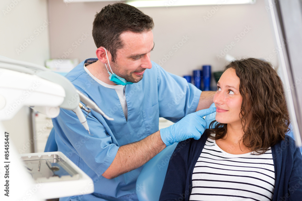 Obraz premium Young attractive dentist explaning his work to a patient