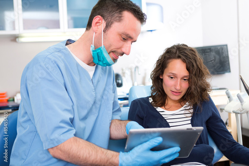 Young attractive woman scared to being cured by a dentist