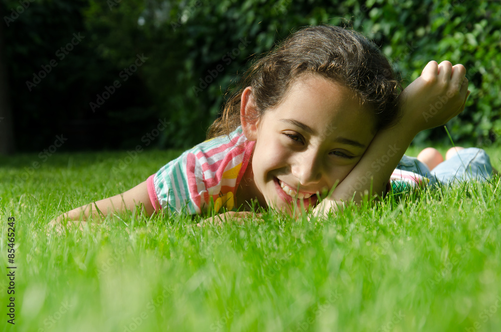 Little girl lying on grass and looking at camera Little girl lying on grass and looking at camera