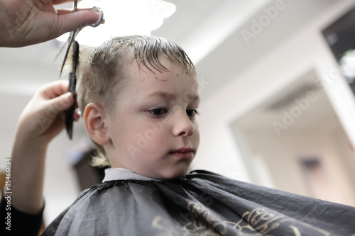 Barber cutting hair of a kid