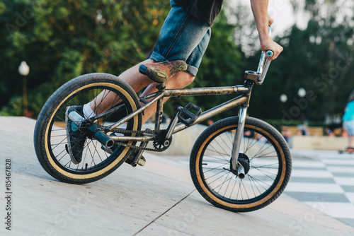 Fototapete BMX-Fahrer auf einem Fahrrad ist bereit, einen Trick auf einer Rampe im Sommer-Skatepark durchzuführen