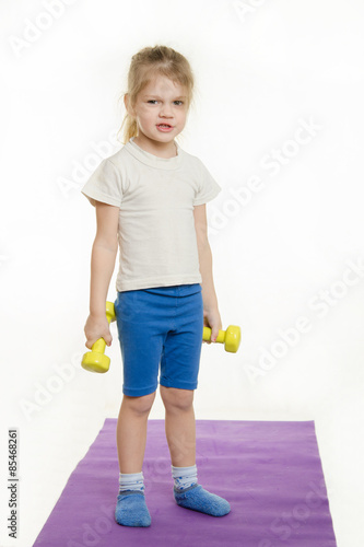 Funny four-year girl with dumbbells