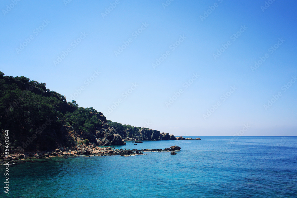 Rocky shore. Southern coast of Turkey. Calm blue sea and clear sky.