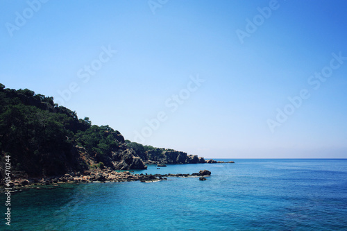 Rocky shore. Southern coast of Turkey. Calm blue sea and clear sky.