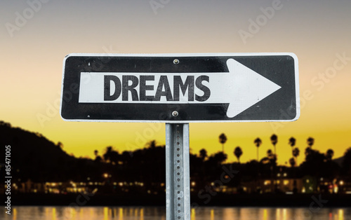 Dreams direction sign with sunset background