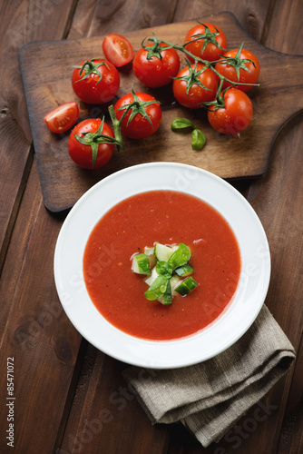 Tomato soup gazpacho over dark rustic wooden background