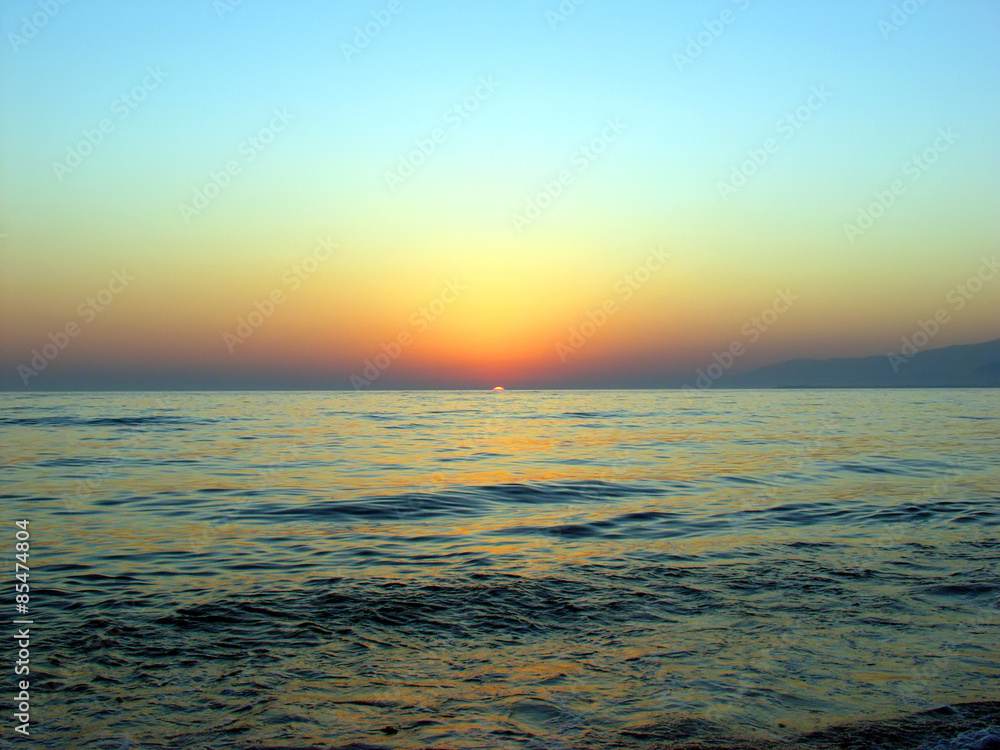 The sun sets over the sea
