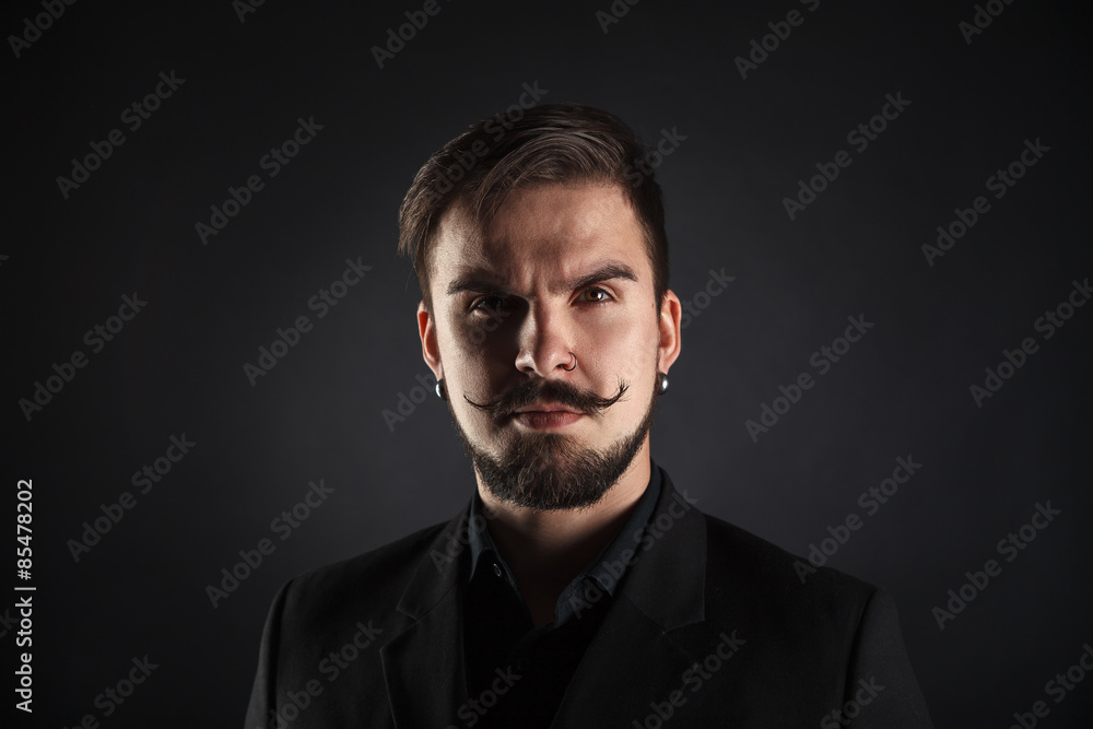 handsome brutal guy with beard on dark background