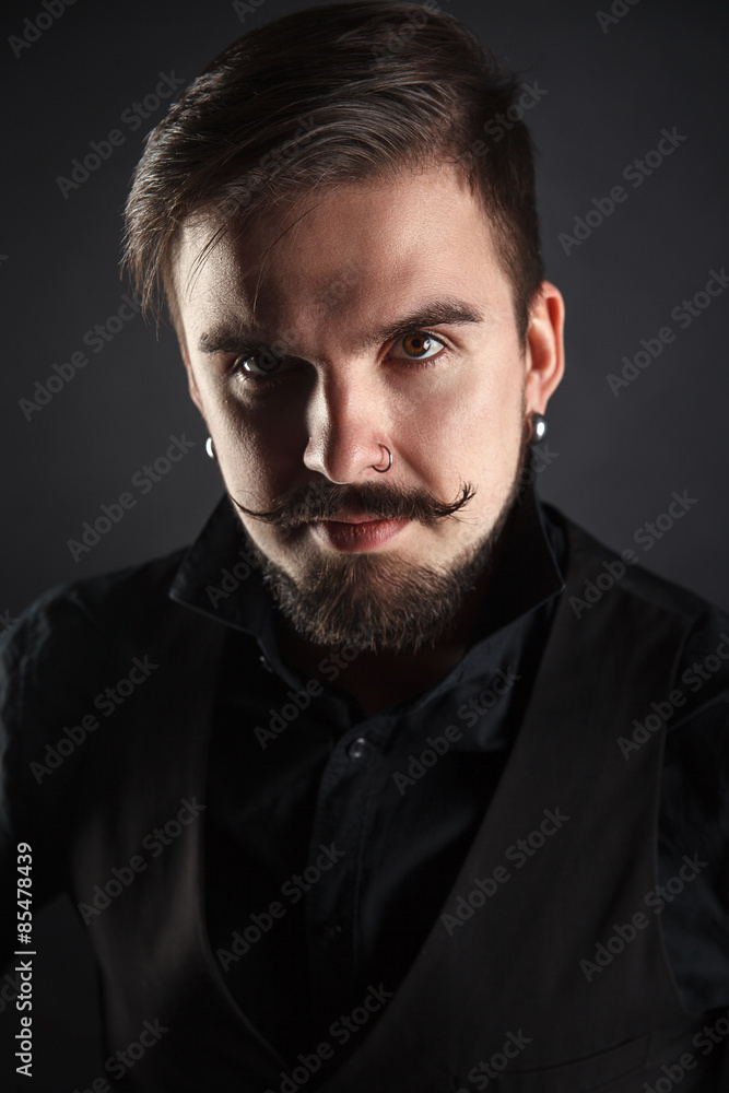 Obraz premium handsome brutal guy with beard on dark background